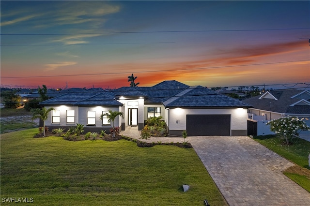 view of front of property with a garage and a lawn