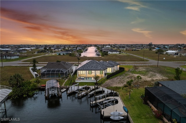 aerial view at dusk featuring a water view