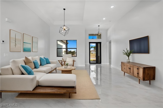 living room featuring a notable chandelier and a high ceiling