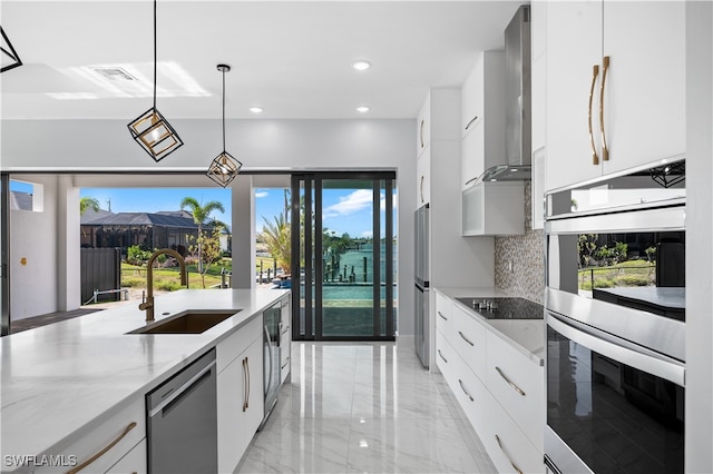 kitchen featuring a wealth of natural light, appliances with stainless steel finishes, sink, and white cabinetry