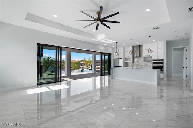 interior space featuring sink, ceiling fan, and a tray ceiling