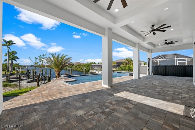 view of swimming pool with a water view, ceiling fan, glass enclosure, and a patio area