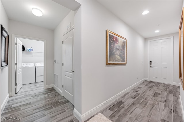 hallway featuring light hardwood / wood-style floors and washer and dryer