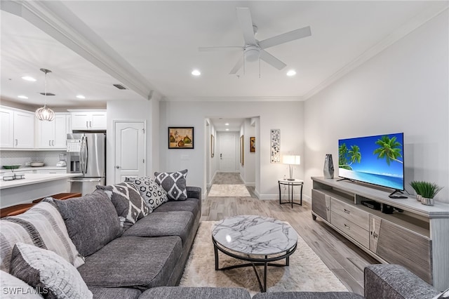 living room featuring crown molding, ceiling fan, and light hardwood / wood-style floors