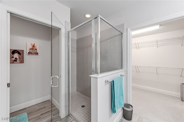 bathroom featuring hardwood / wood-style floors and a shower with shower door