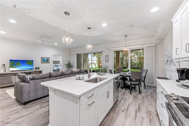 kitchen with sink, decorative light fixtures, a center island with sink, light hardwood / wood-style flooring, and white cabinetry