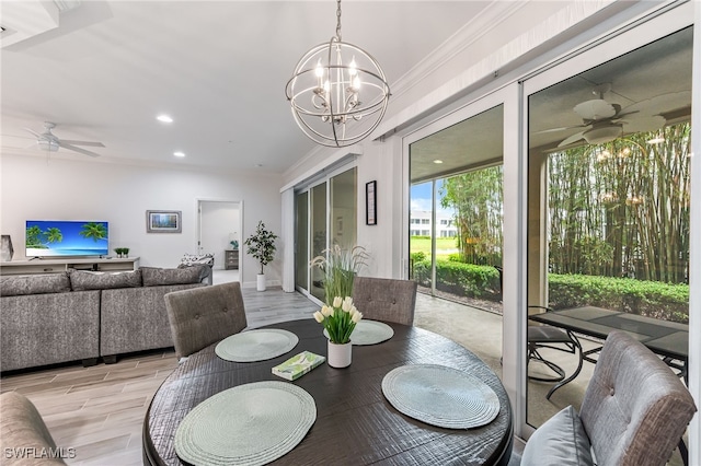 dining space featuring ceiling fan with notable chandelier, light wood-type flooring, and crown molding