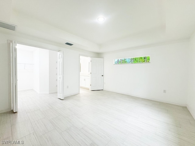 unfurnished room featuring a tray ceiling