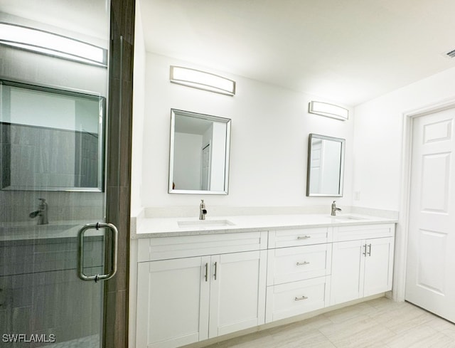 bathroom with vanity and a shower with shower door