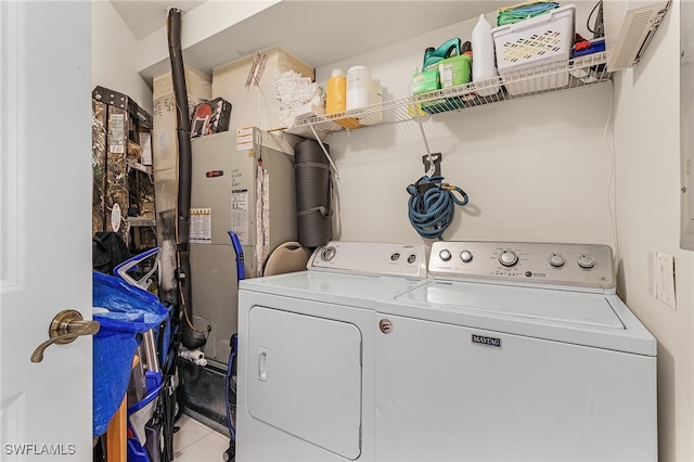 clothes washing area with washer and clothes dryer and light tile patterned floors