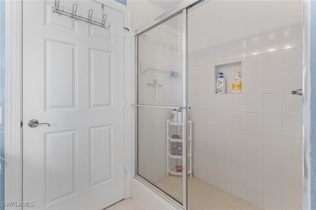 bathroom featuring a shower with door and tile patterned flooring