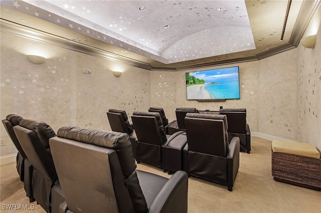 home theater room with lofted ceiling, light colored carpet, and a raised ceiling