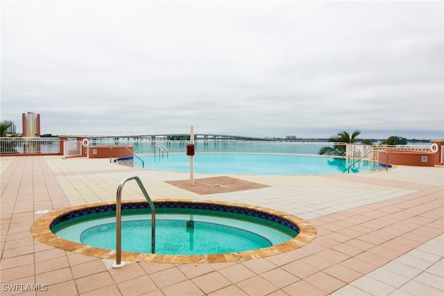 view of pool with a hot tub and a patio