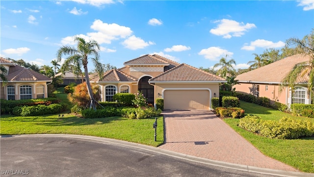 mediterranean / spanish house featuring a garage and a front lawn