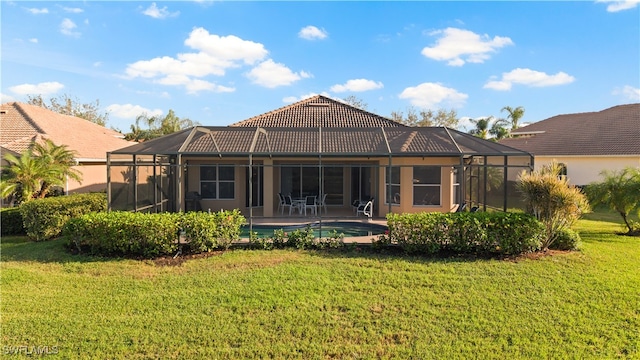 back of house with a lawn and glass enclosure