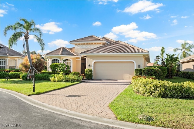 mediterranean / spanish house with a front yard and a garage