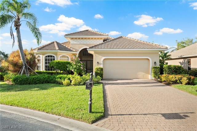 mediterranean / spanish home with a front yard and a garage