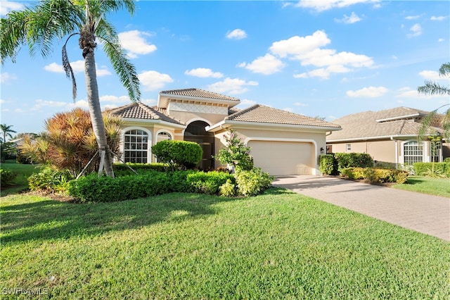 mediterranean / spanish house with a front lawn and a garage