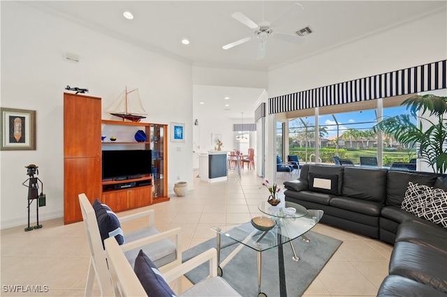 tiled living room with ceiling fan and crown molding