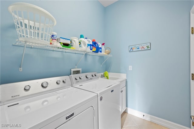 washroom featuring cabinets, washing machine and dryer, sink, and light tile patterned flooring