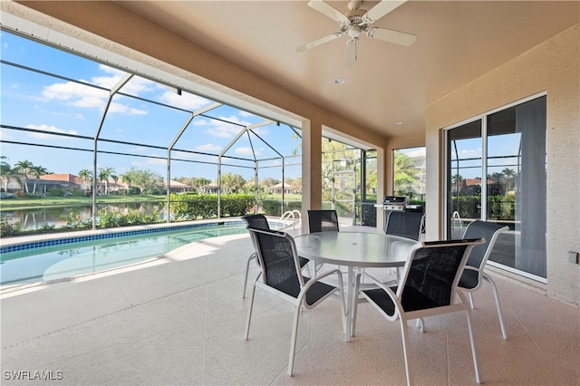 view of patio / terrace with glass enclosure, ceiling fan, and a water view