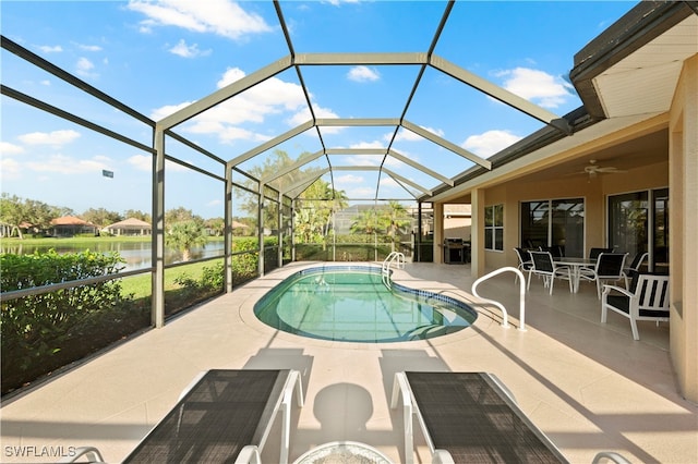 view of pool with a patio, a water view, ceiling fan, and a lanai