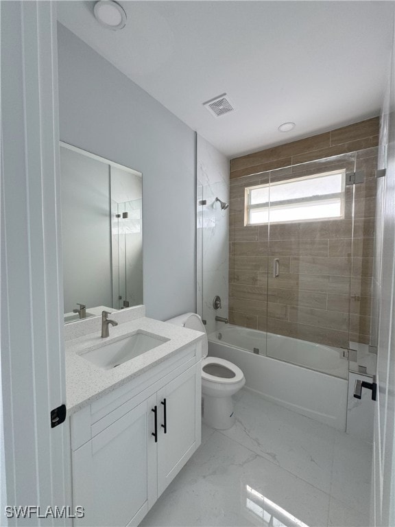 full bathroom featuring vanity, shower / bath combination with glass door, and toilet