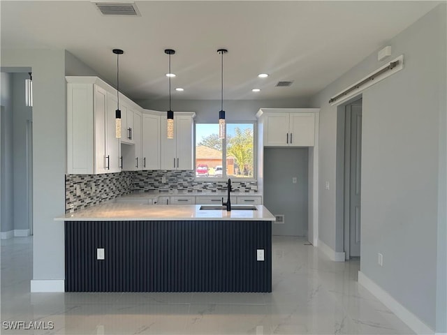 kitchen with pendant lighting, sink, decorative backsplash, and white cabinets