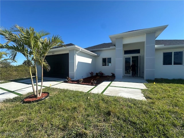 back of house featuring a yard and a garage