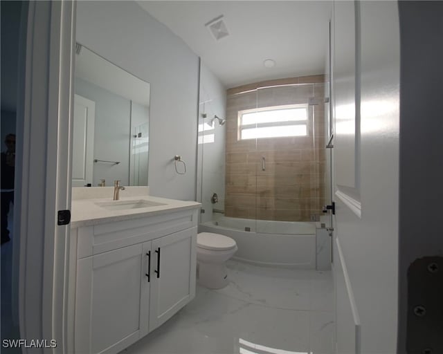 full bathroom featuring vanity, shower / bath combination with glass door, and toilet