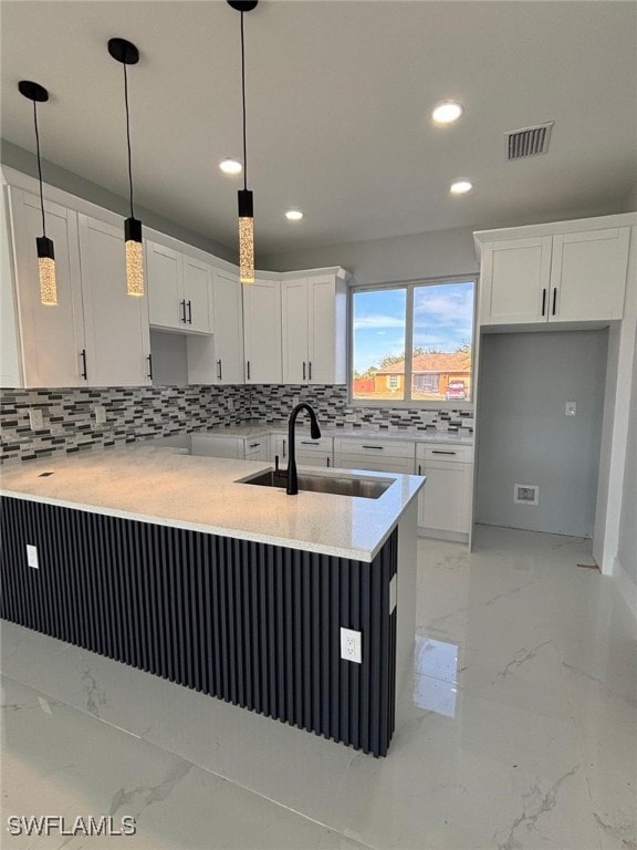 kitchen featuring white cabinetry, kitchen peninsula, sink, and hanging light fixtures