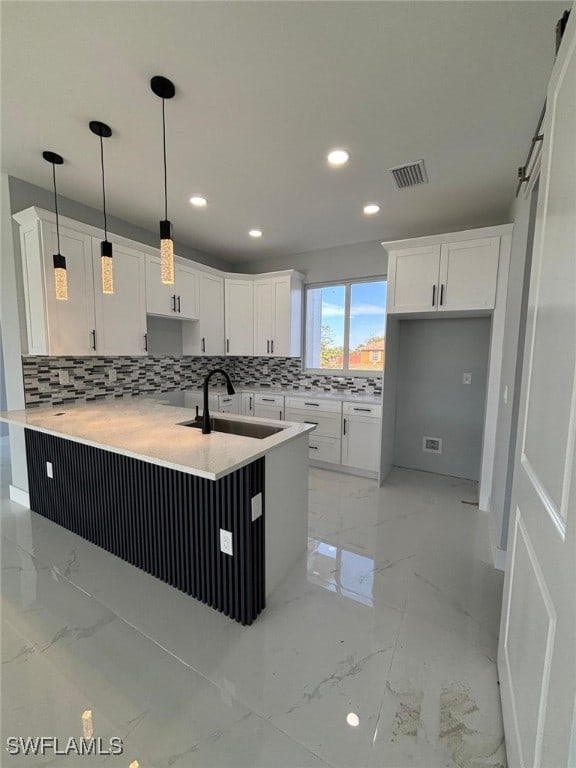 kitchen featuring sink, decorative backsplash, white cabinets, decorative light fixtures, and kitchen peninsula