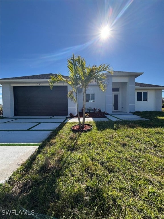 single story home featuring a garage and a front lawn