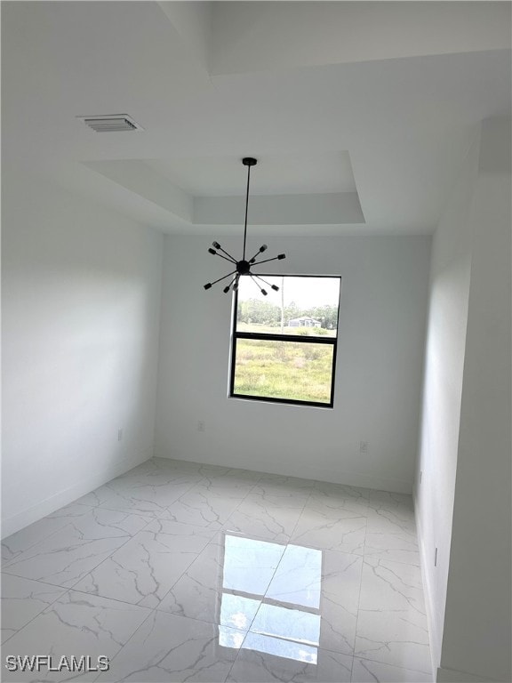 unfurnished room with a tray ceiling