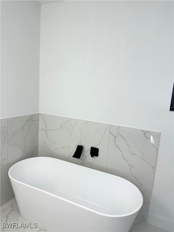 bathroom with tile walls and a washtub