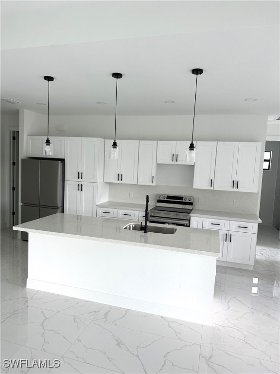 kitchen featuring hanging light fixtures, appliances with stainless steel finishes, and a kitchen island with sink