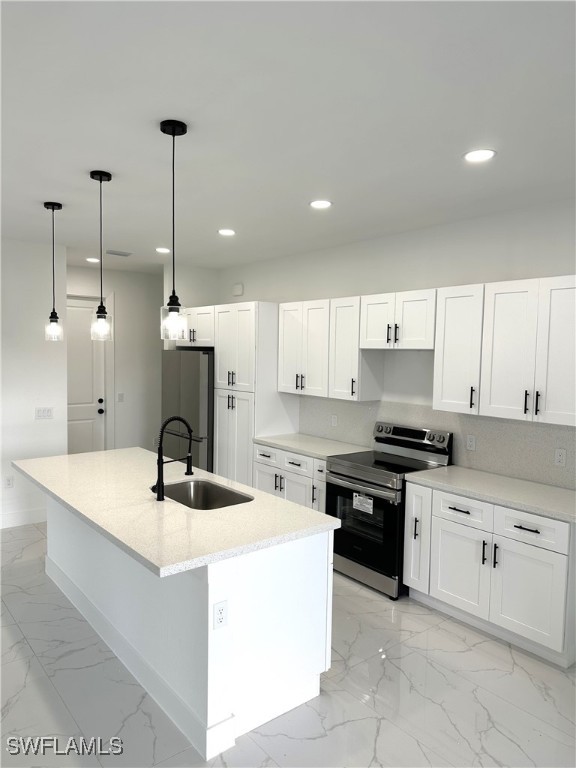 kitchen featuring white cabinets, stainless steel appliances, sink, and decorative light fixtures