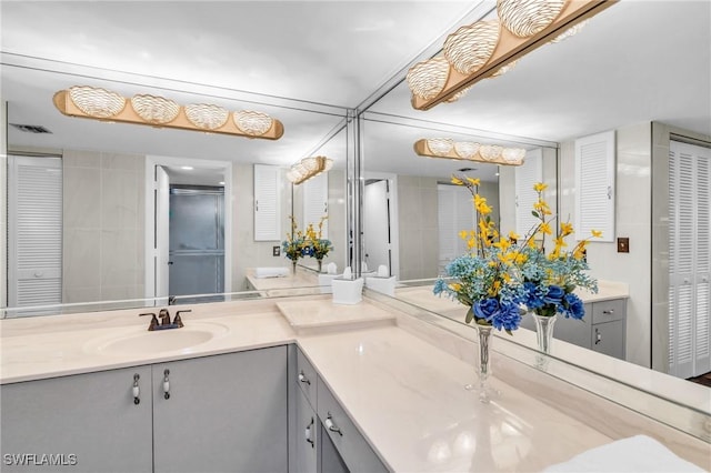 full bathroom featuring visible vents, vanity, and a closet