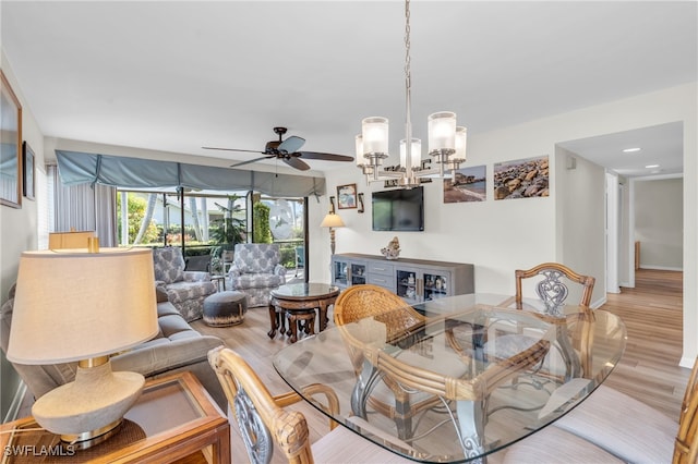 living room featuring light wood-type flooring and ceiling fan with notable chandelier