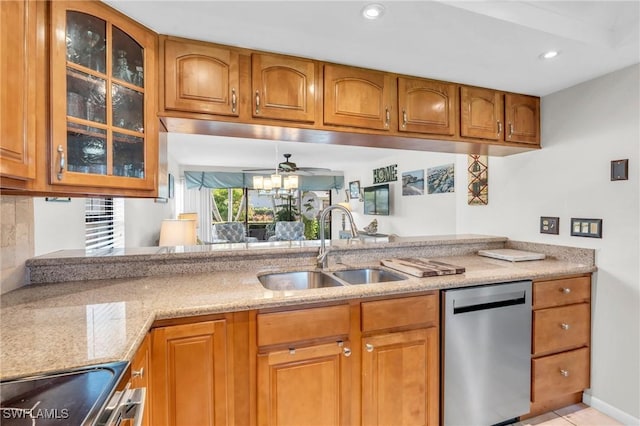 kitchen featuring light stone countertops, ceiling fan, sink, stainless steel dishwasher, and stove