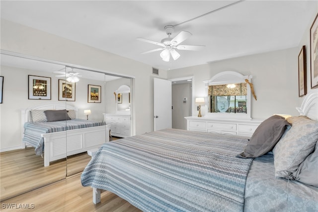 bedroom with light wood-type flooring, a closet, and ceiling fan