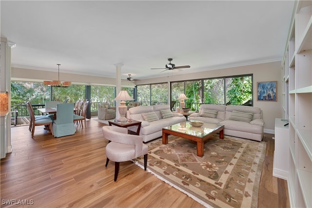 living room with ornamental molding, light hardwood / wood-style flooring, and ceiling fan