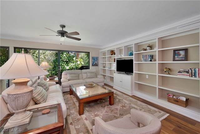 living room with wood-type flooring, ornamental molding, and ceiling fan