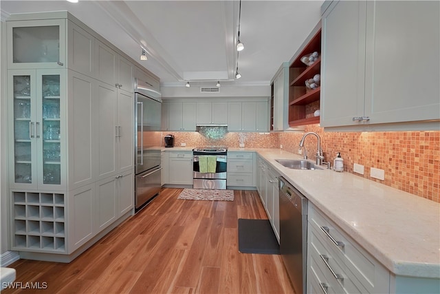 kitchen featuring light wood-type flooring, decorative backsplash, sink, and stainless steel appliances