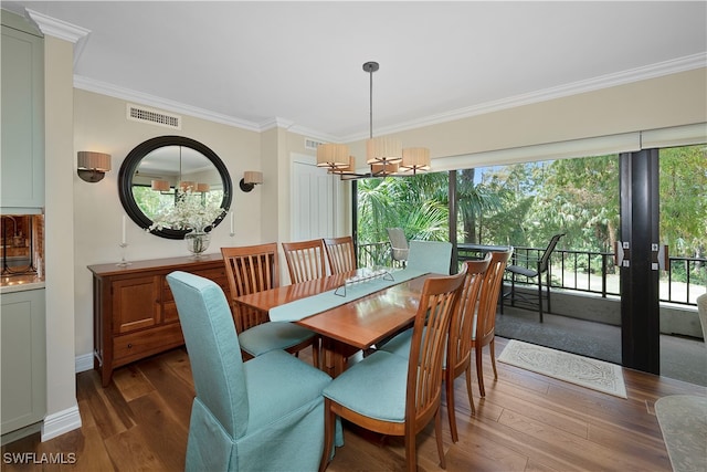 dining room with wood-type flooring, plenty of natural light, and a chandelier