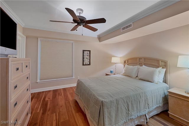 bedroom featuring crown molding, light hardwood / wood-style flooring, and ceiling fan