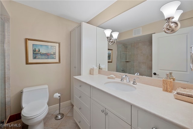 bathroom with tiled shower, tile patterned floors, vanity, and toilet