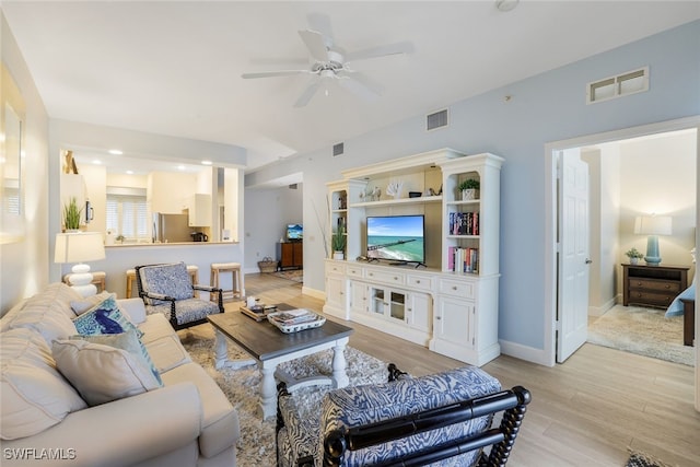 living room with light wood-type flooring and ceiling fan