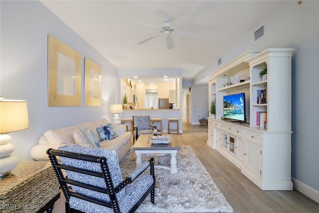 living room featuring light hardwood / wood-style floors and ceiling fan