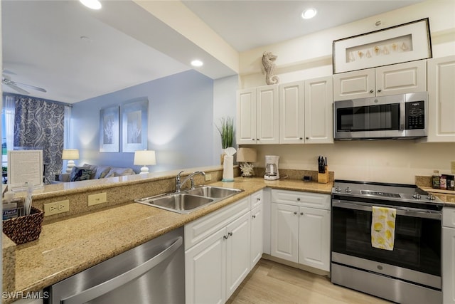 kitchen with ceiling fan, sink, light hardwood / wood-style floors, white cabinetry, and appliances with stainless steel finishes